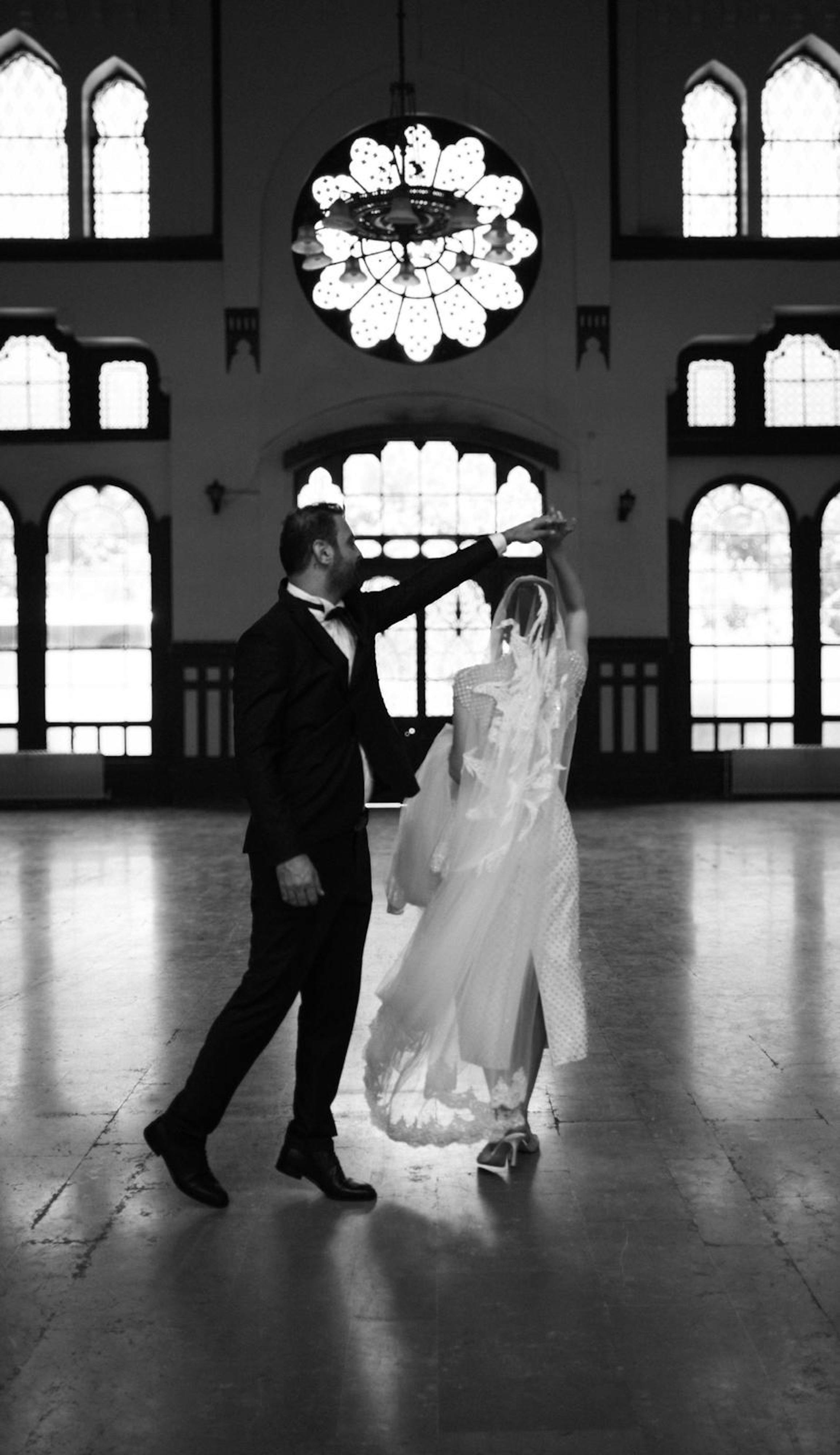 a bride and groom dance in the ballroom