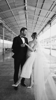 Stylish black and white portrait of a bride and groom indoors.