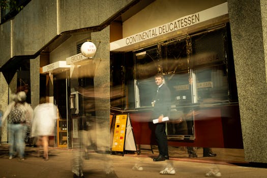 Blurred movement outside a Continental Delicatessen in Brisbane, capturing urban life and commerce.
