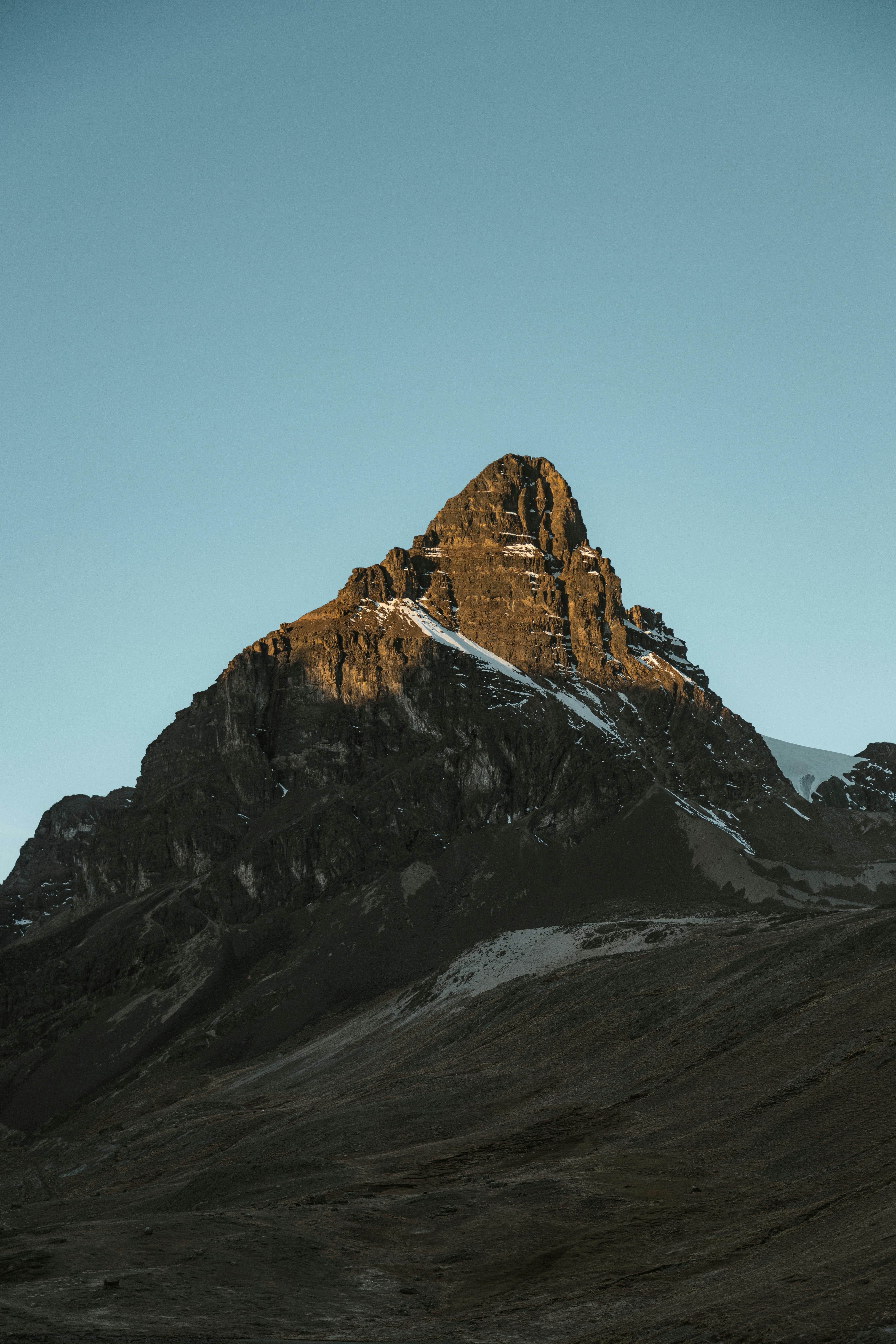 a mountain peak is silhouetted against the sky