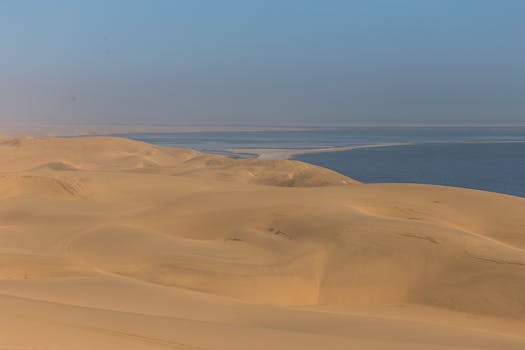 Vast tranquil dunes of Namibia's desert softly blend into the dramatic ocean view.