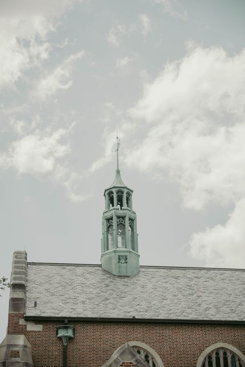 Free Close-up of a church tower with an intricate design set against a cloudy sky in Chicago. Stock Photo
