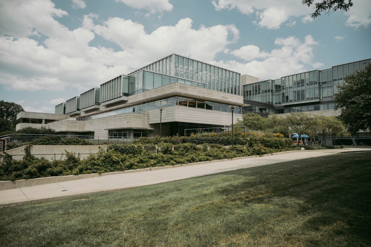Modern glass and concrete university building surrounded by greenery
