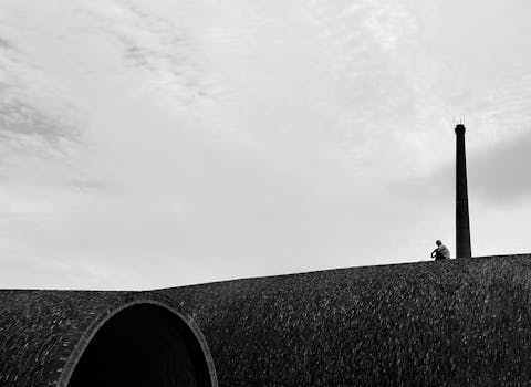 Black and white photo of a person sitting on a curved rooftop in Jingdezhen, Jiangxi, China.