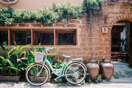 Free A vintage bicycle leans against a rustic brick wall in Hanoi, Vietnam, showcasing traditional charm. Stock Photo