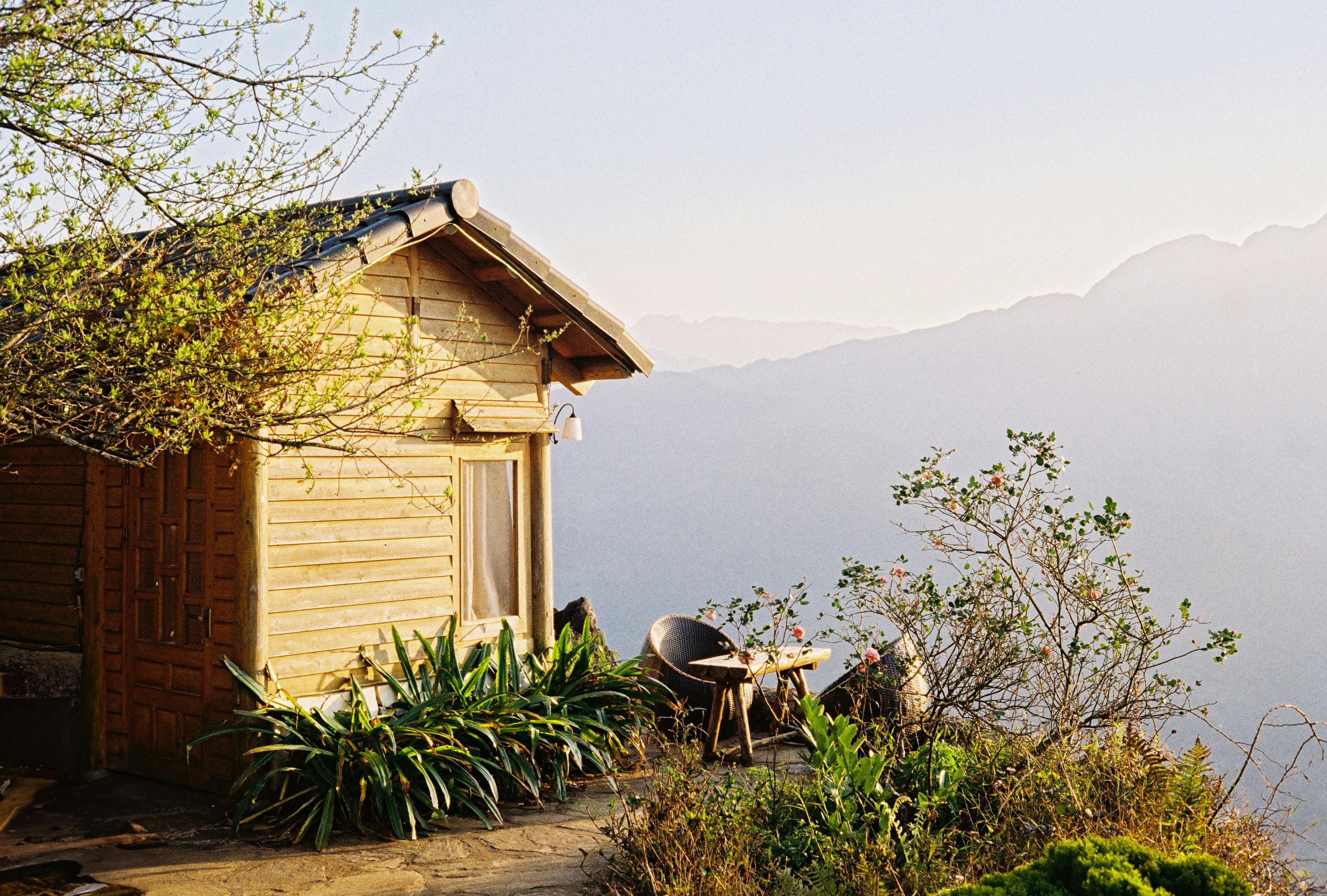 Peaceful wooden cabin set against the backdrop of Lào Cai mountains during sunrise.