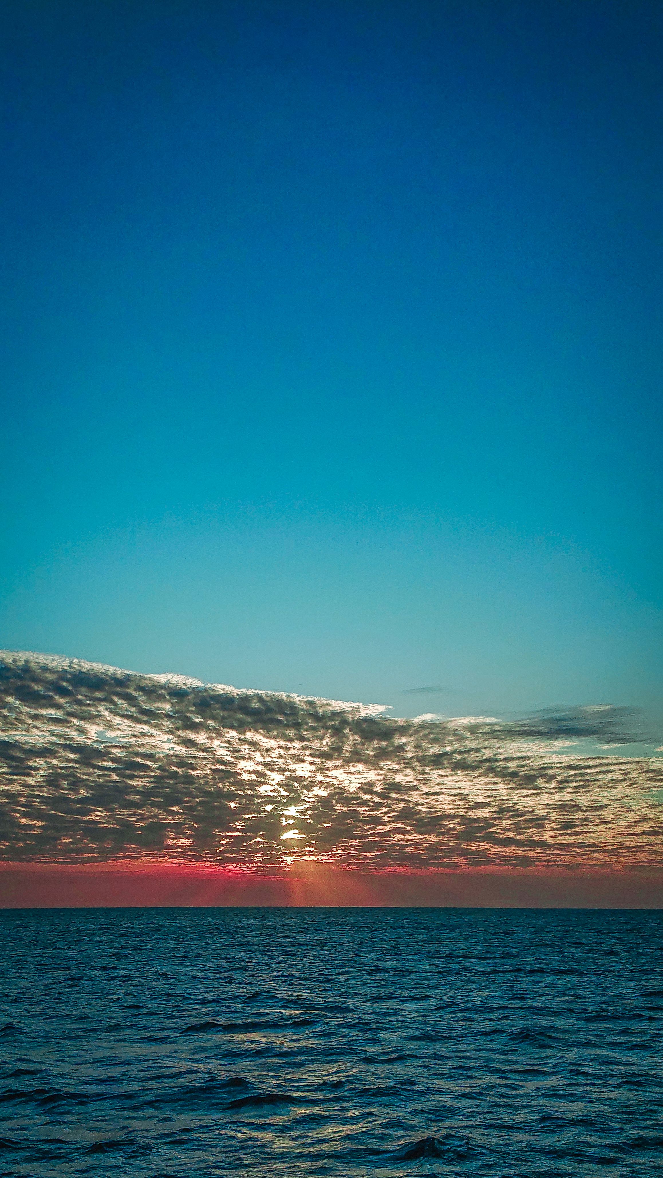 Breathtaking sunset view over the calm ocean in Zanzibar, Tanzania, capturing the beauty of the sky and sea.