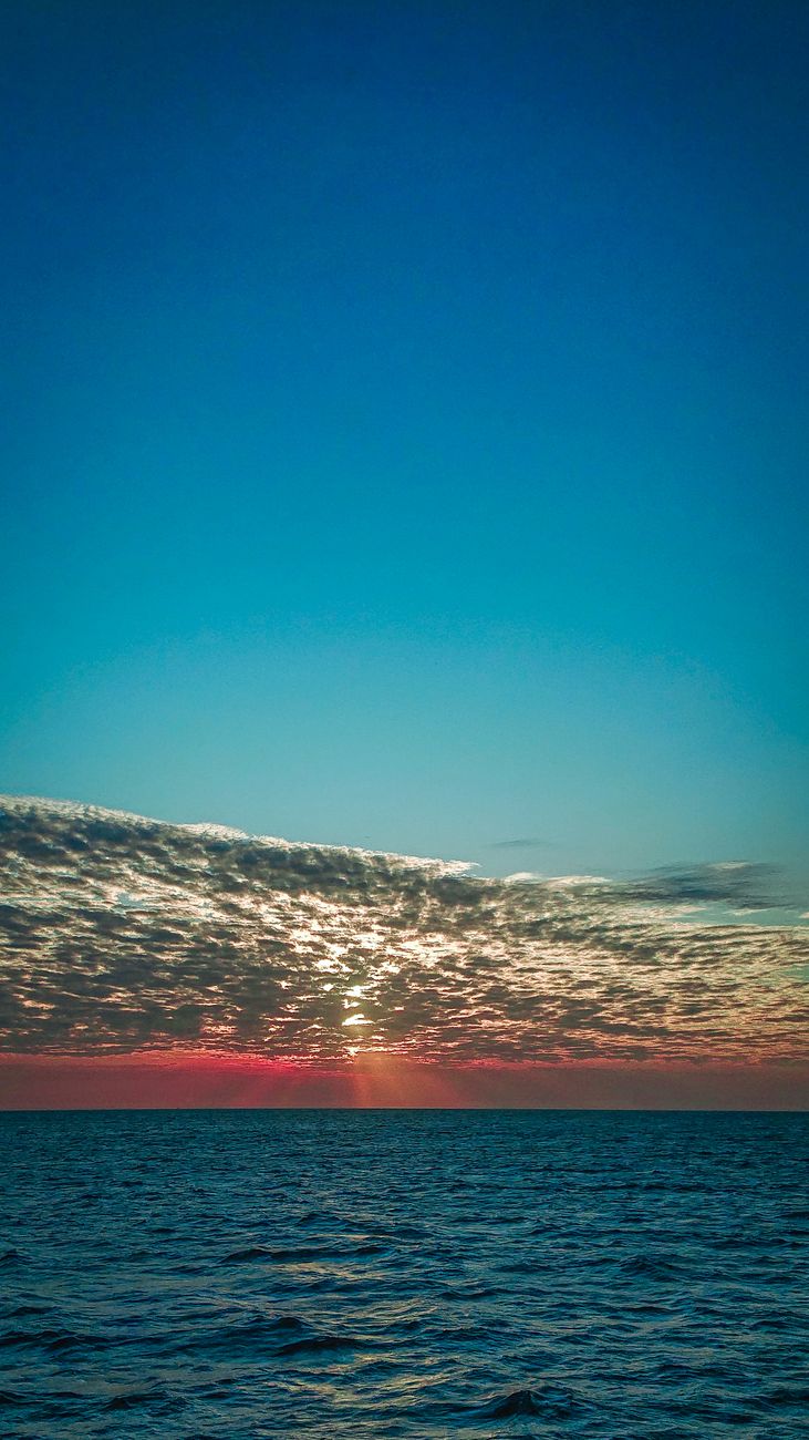 Breathtaking sunset view over the calm ocean in Zanzibar, Tanzania, capturing the beauty of the sky and sea.