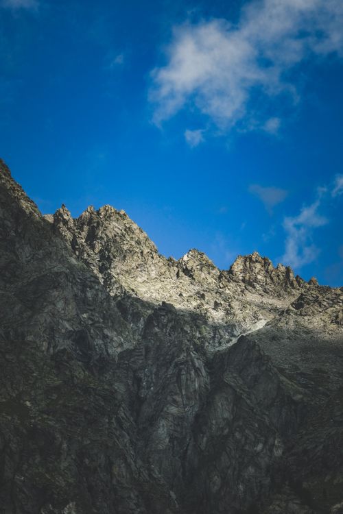 Free Majestic rocky mountain peaks against a vivid blue sky, ideal for adventure themes. Stock Photo