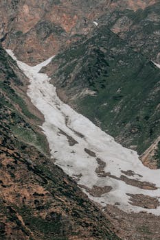 Stunning aerial shot of a snow-covered valley in rugged mountainous terrain.