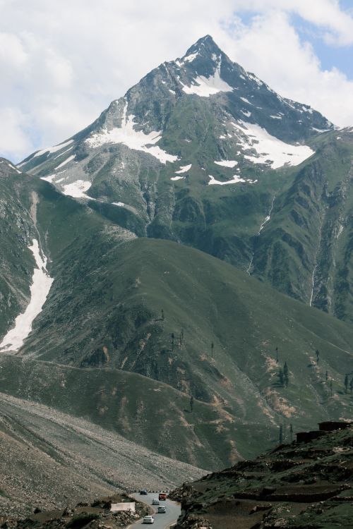 Free Stunning snow-capped mountain peak with lush green valleys, perfect for nature and adventure fans. Stock Photo