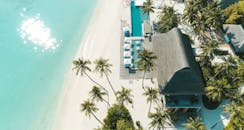 热带度假村的海滩鸟瞰图令人惊叹，棕榈树、碧绿的海水和白沙尽收眼底