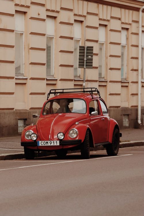 Free Vintage red Volkswagen Beetle parked on a street in Jönköping, Sweden, showcasing classic car design. Stock Photo