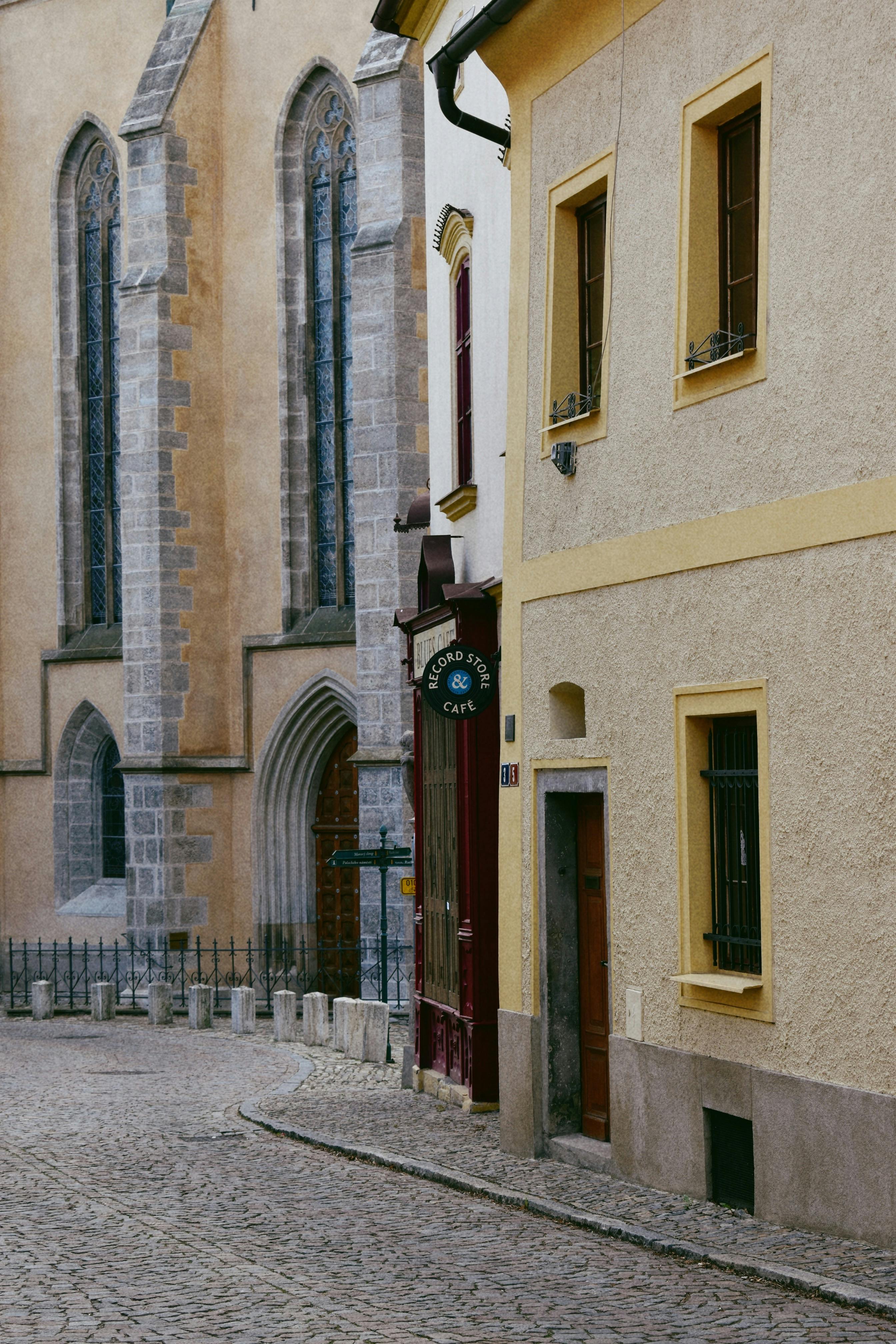 Narrow cobblestone street beside a Gothic church facade in a quaint European town.