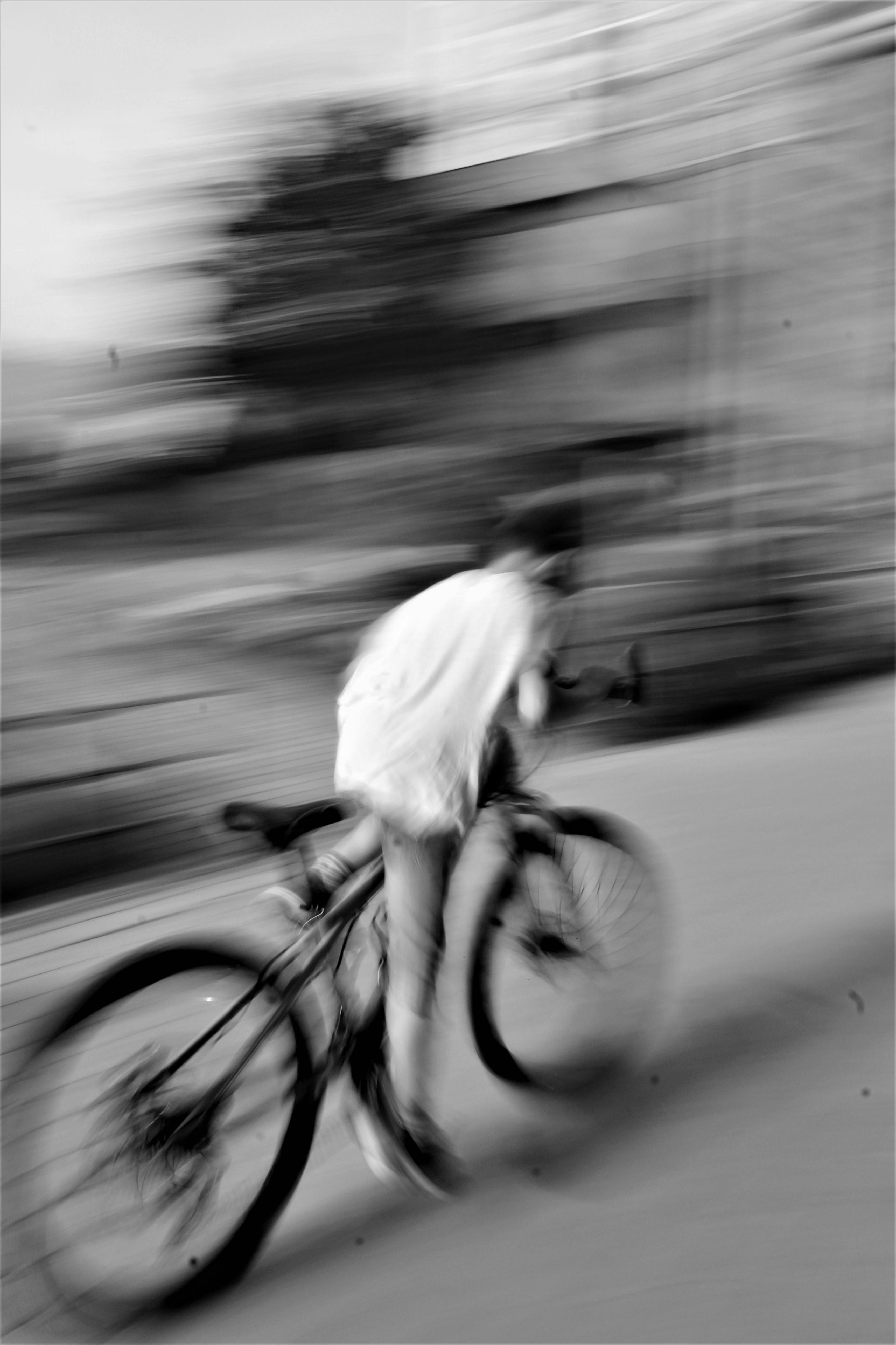 grayscale photography of person riding bicycle
