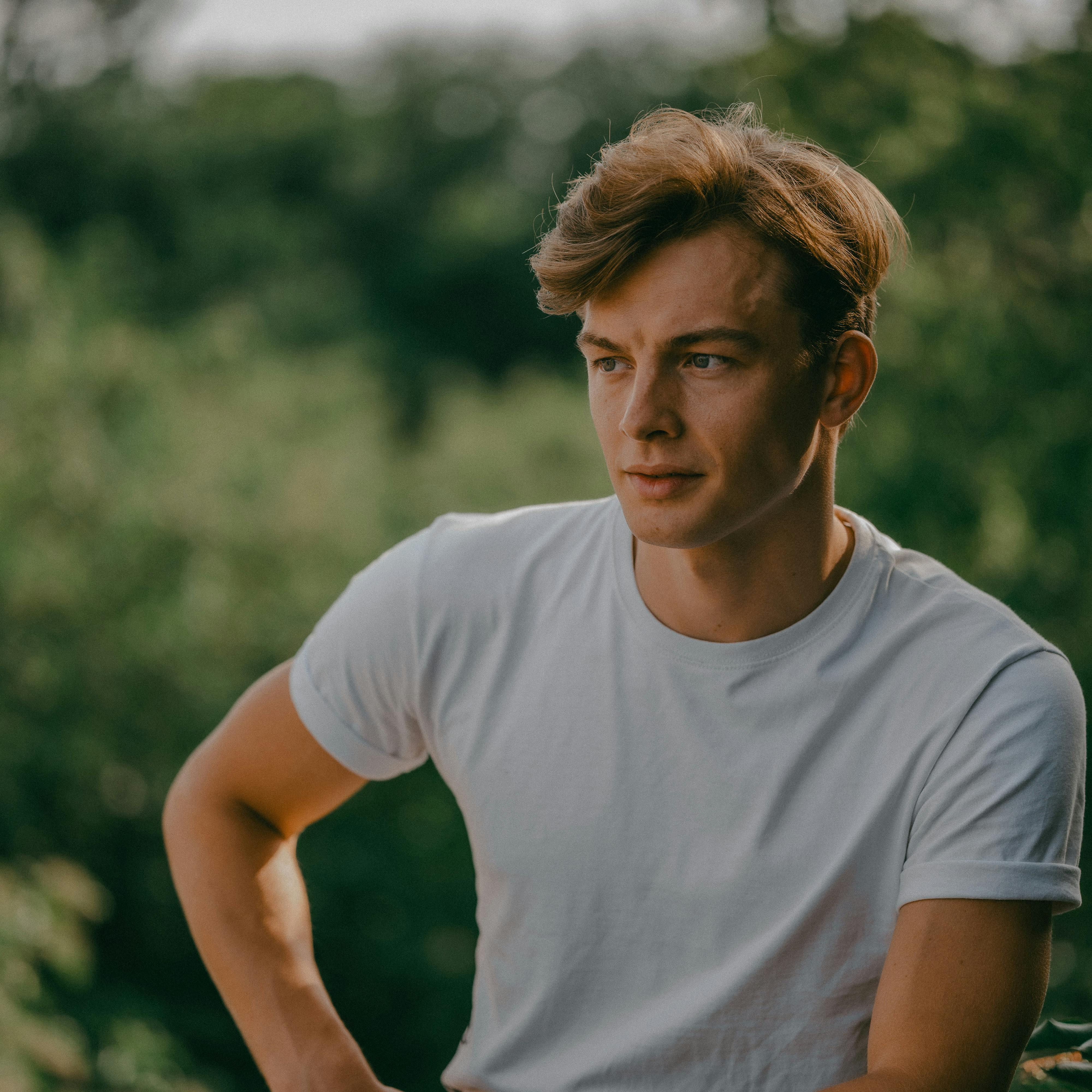 a man in a white t shirt sitting on a bench