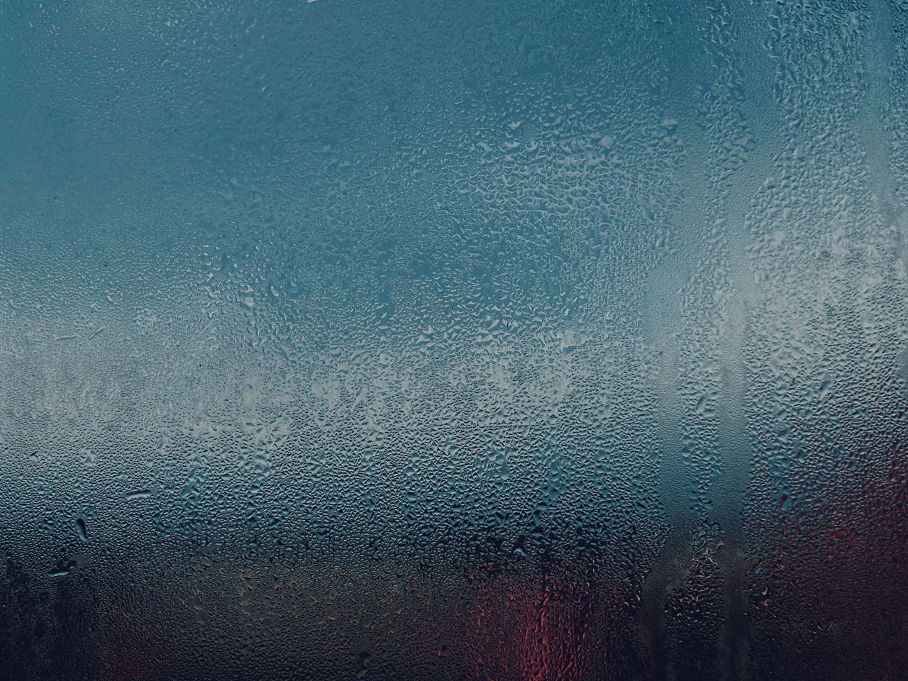 dramatic close up of raindrops on a window showcasing a textured moody