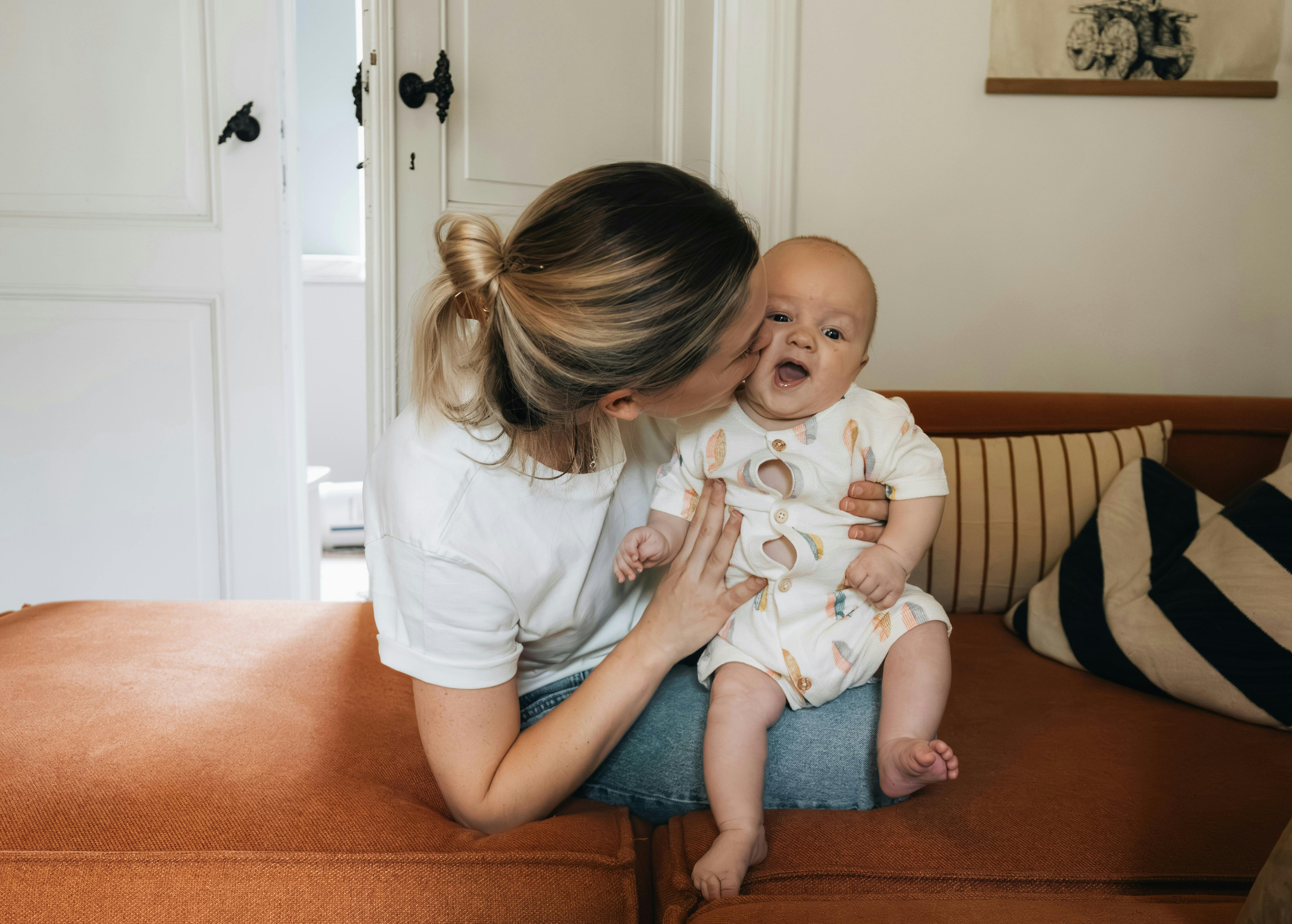 a woman holding a baby on a couch