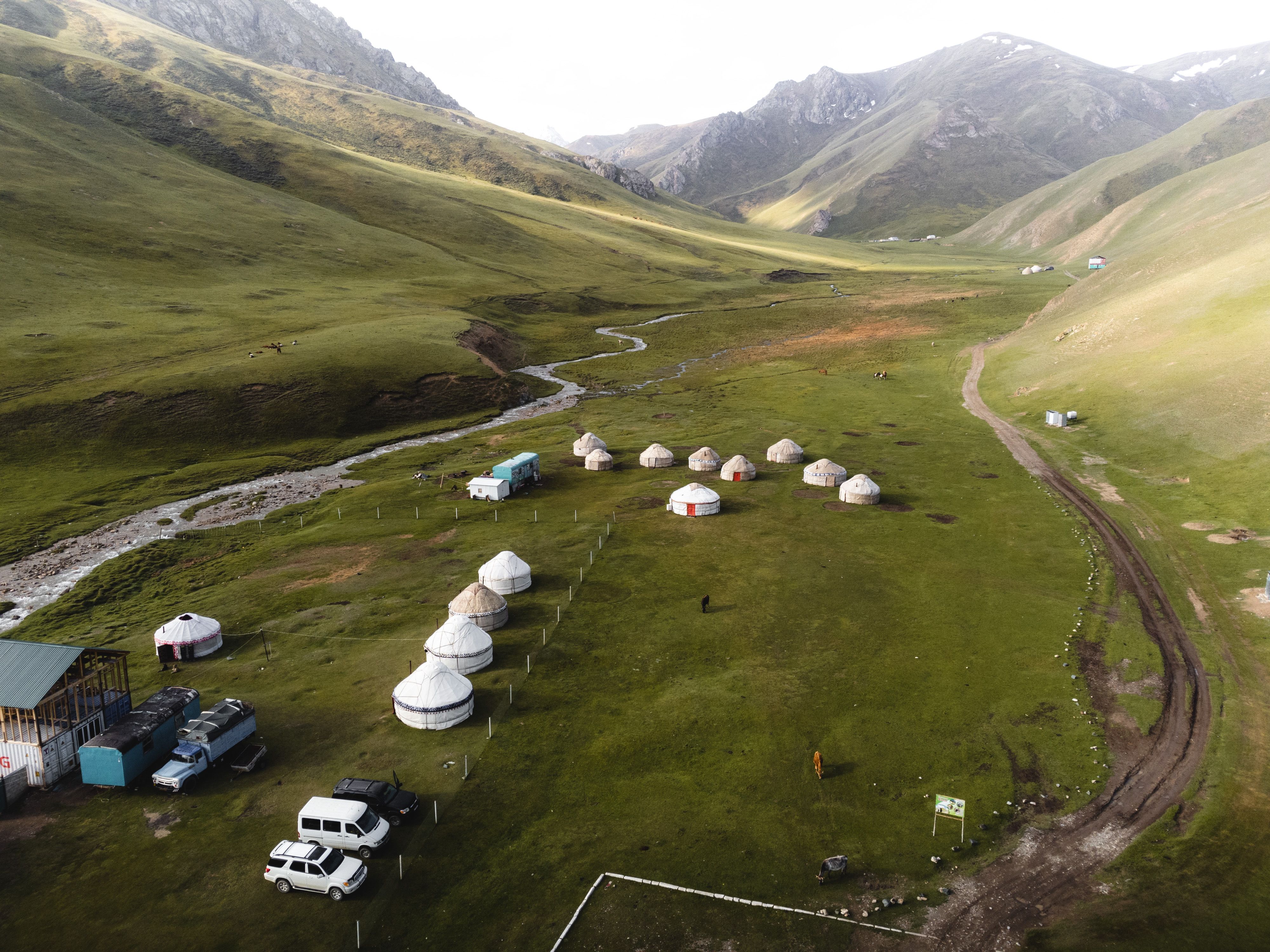Discover tranquil yurts nestled in a vast mountain valley, perfect for a serene getaway.