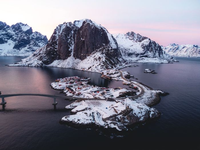 Snow-covered fishing village below Lofoten peaks — photo by Tomáš Malík on Pexels
