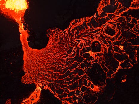A breathtaking aerial view of flowing lava, showcasing vibrant red hues and geological textures.