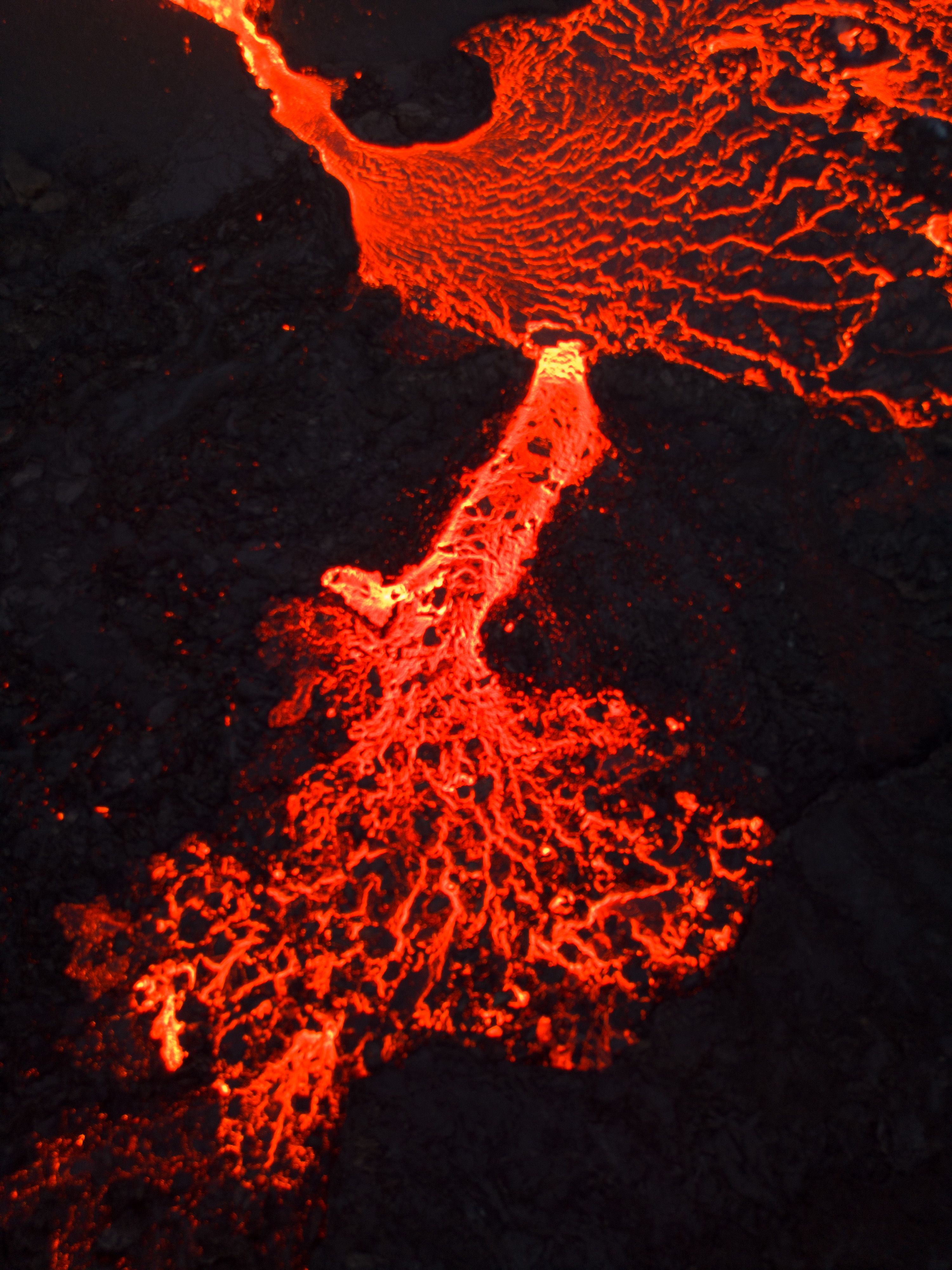 Close-up of vibrant molten lava flow with intricate textures in an Icelandic volcanic landscape.