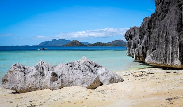 Stunning view of a rocky beach in Coron, Philippines, with turquoise waters and blue skies.