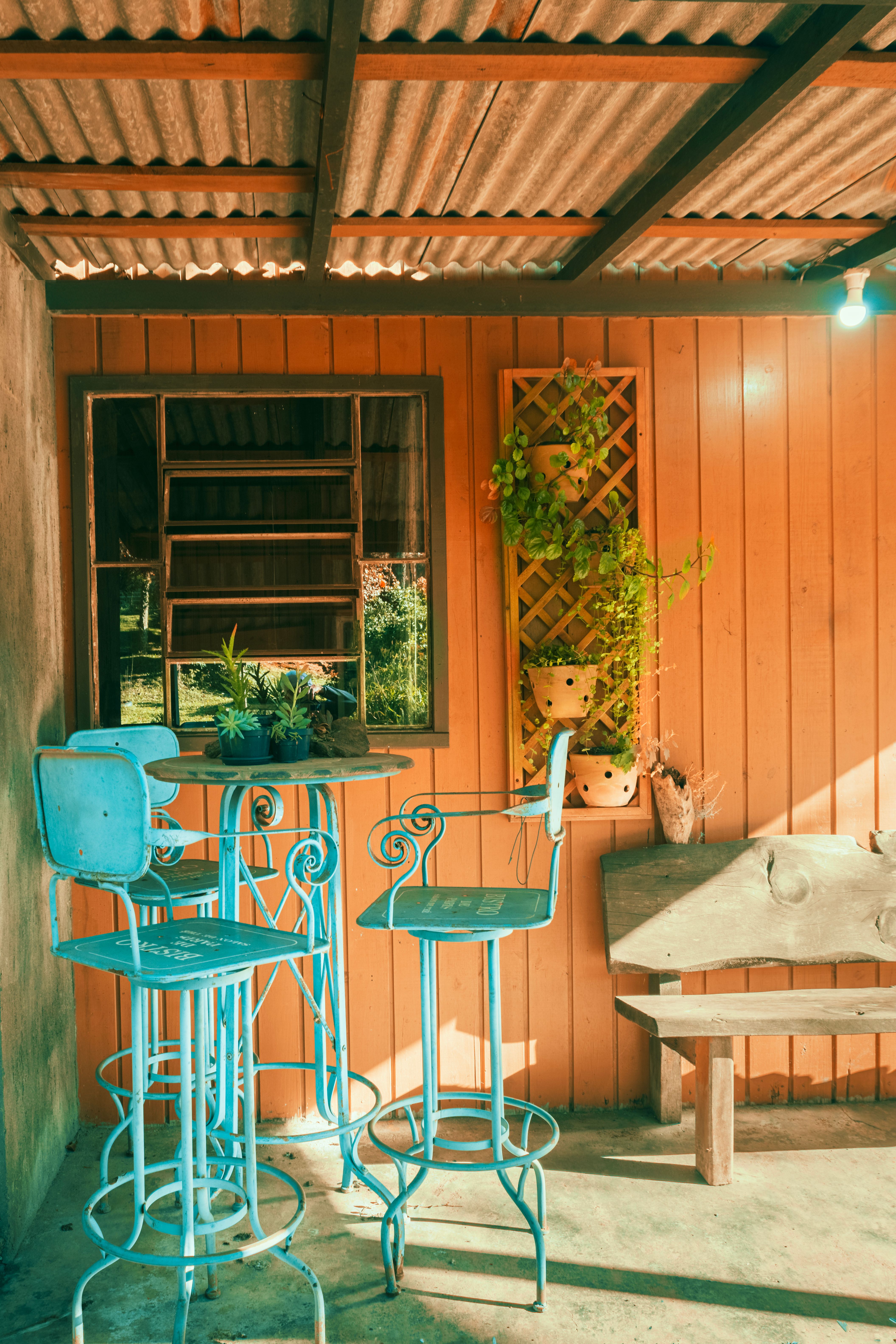 Bright rustic patio featuring vintage blue furniture and wooden walls, creating a warm and inviting atmosphere.