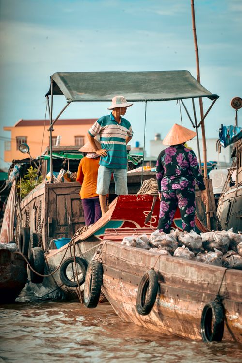 Free Locals trading goods on boats at bustling Cần Thơ floating market. Stock Photo