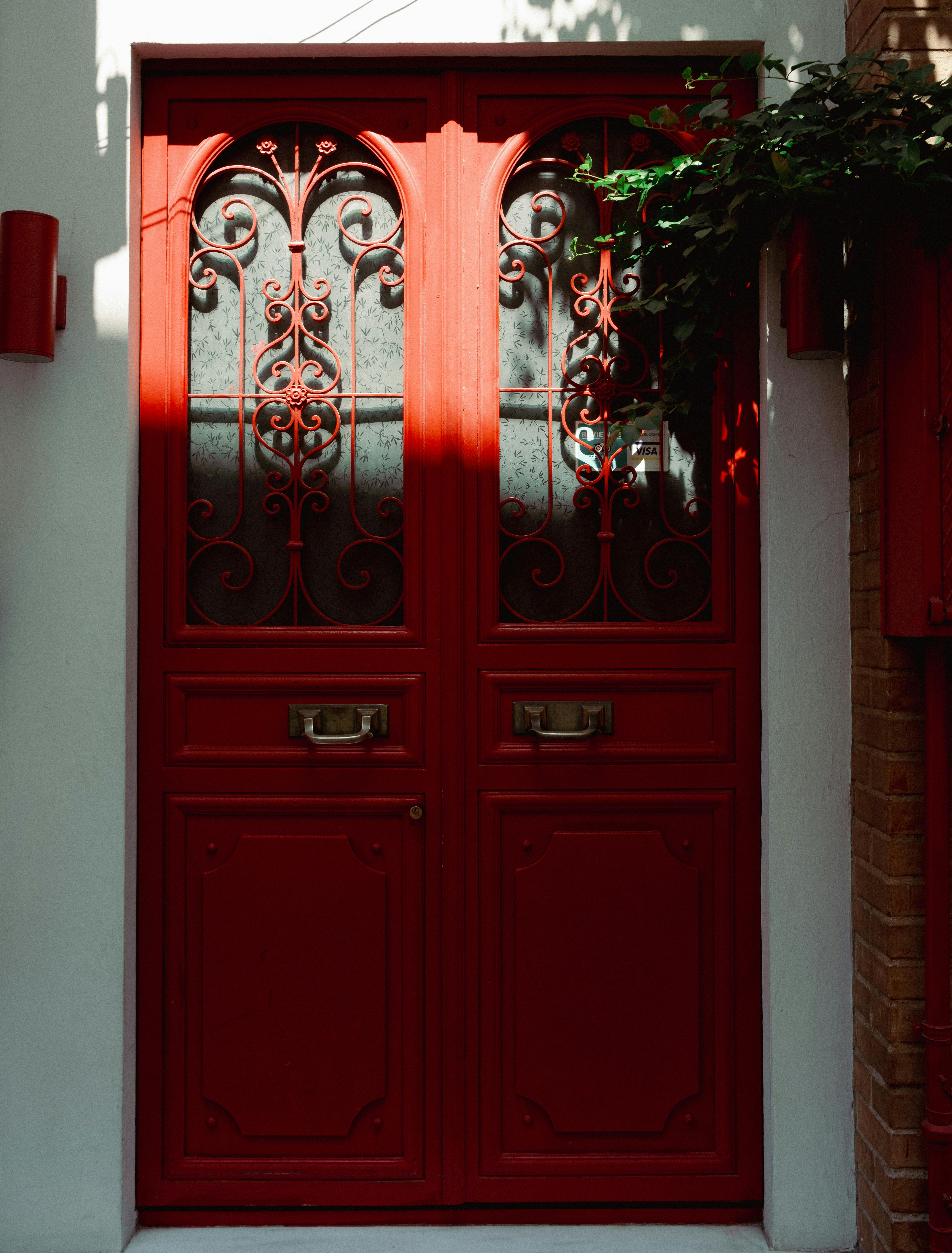 A striking red door with intricate ironwork, surrounded by classic architectural details, in İstanbul, Türkiye.