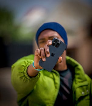 A person showcases a smartphone outdoors, focusing on the device.