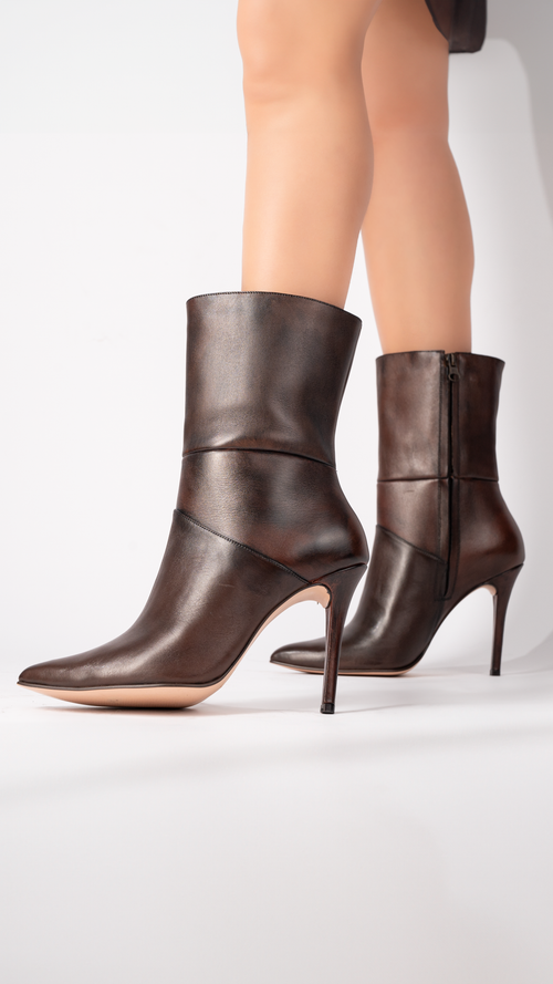 Free Stylish brown leather stiletto boots perfect for fashion-forward outfits. Stock Photo