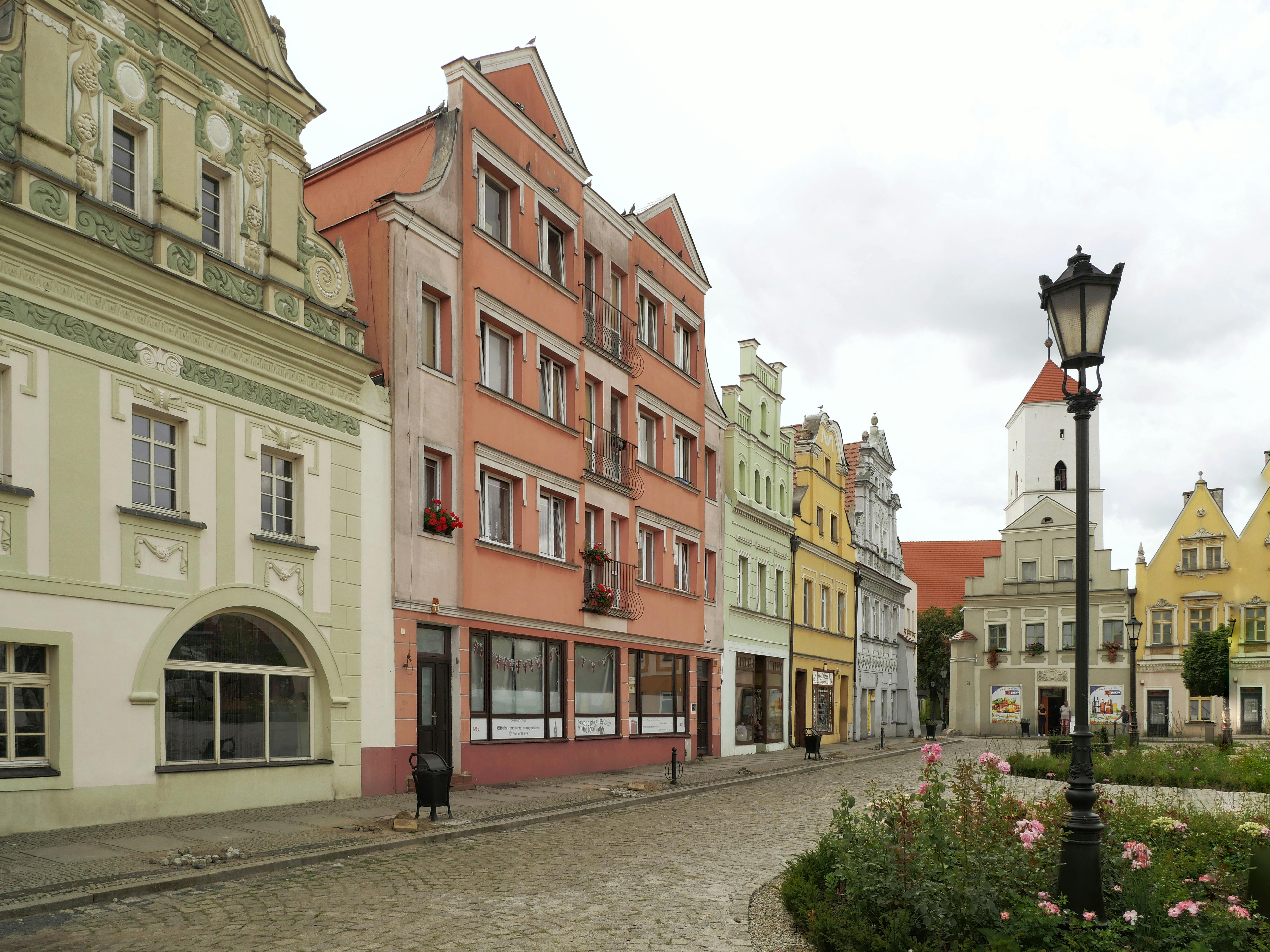 Historic buildings line a quaint town square in Bytom Odrzański, Poland, showcasing vibrant architecture.