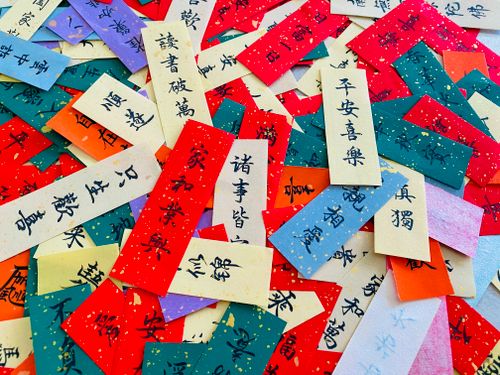 Free Vibrant paper slips with Chinese calligraphy, symbolizing good fortune and traditional cultural elements. Stock Photo