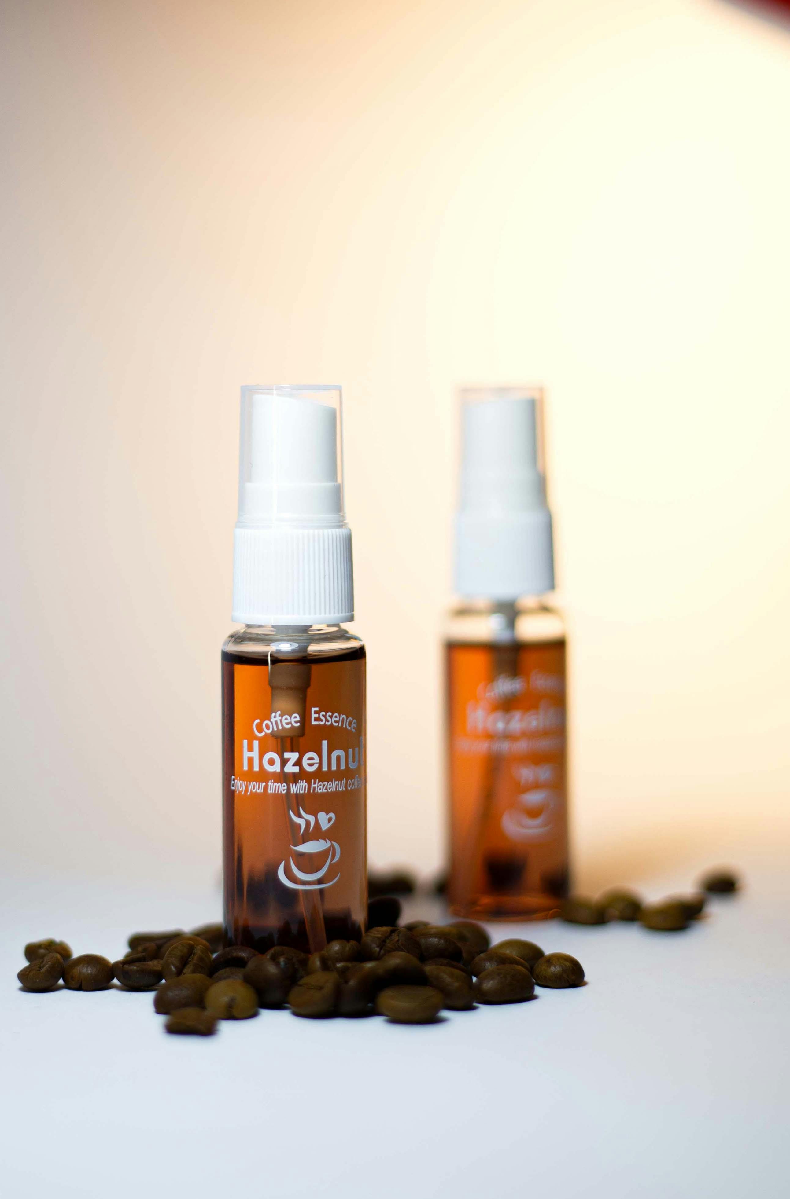 Close-up of hazelnut coffee essence bottles surrounded by coffee beans, showcasing luxury and aroma.