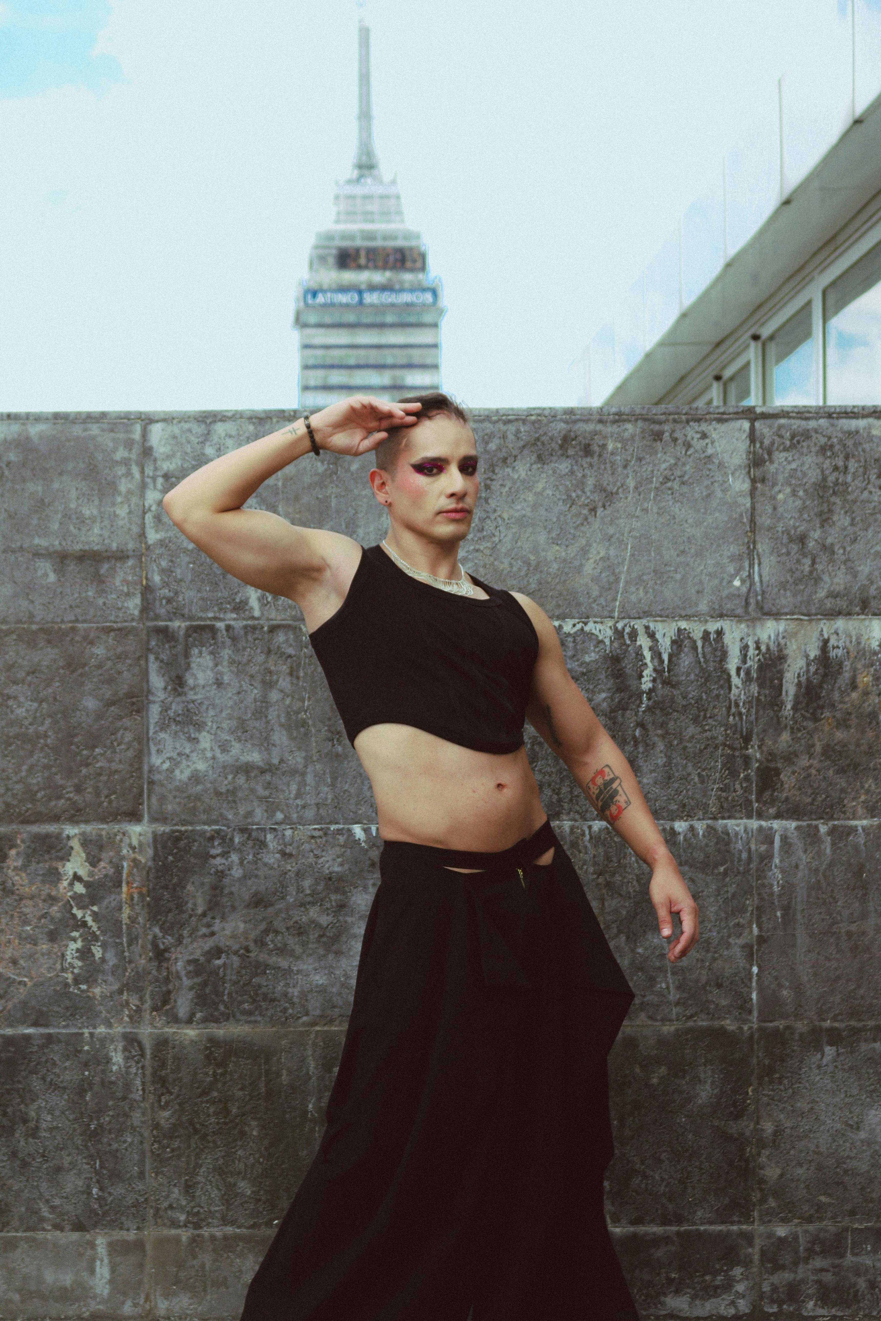 Stylish individual fashionably posing in front of a city landmark.