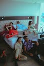 Young People Around a Bed in a Hotel Room