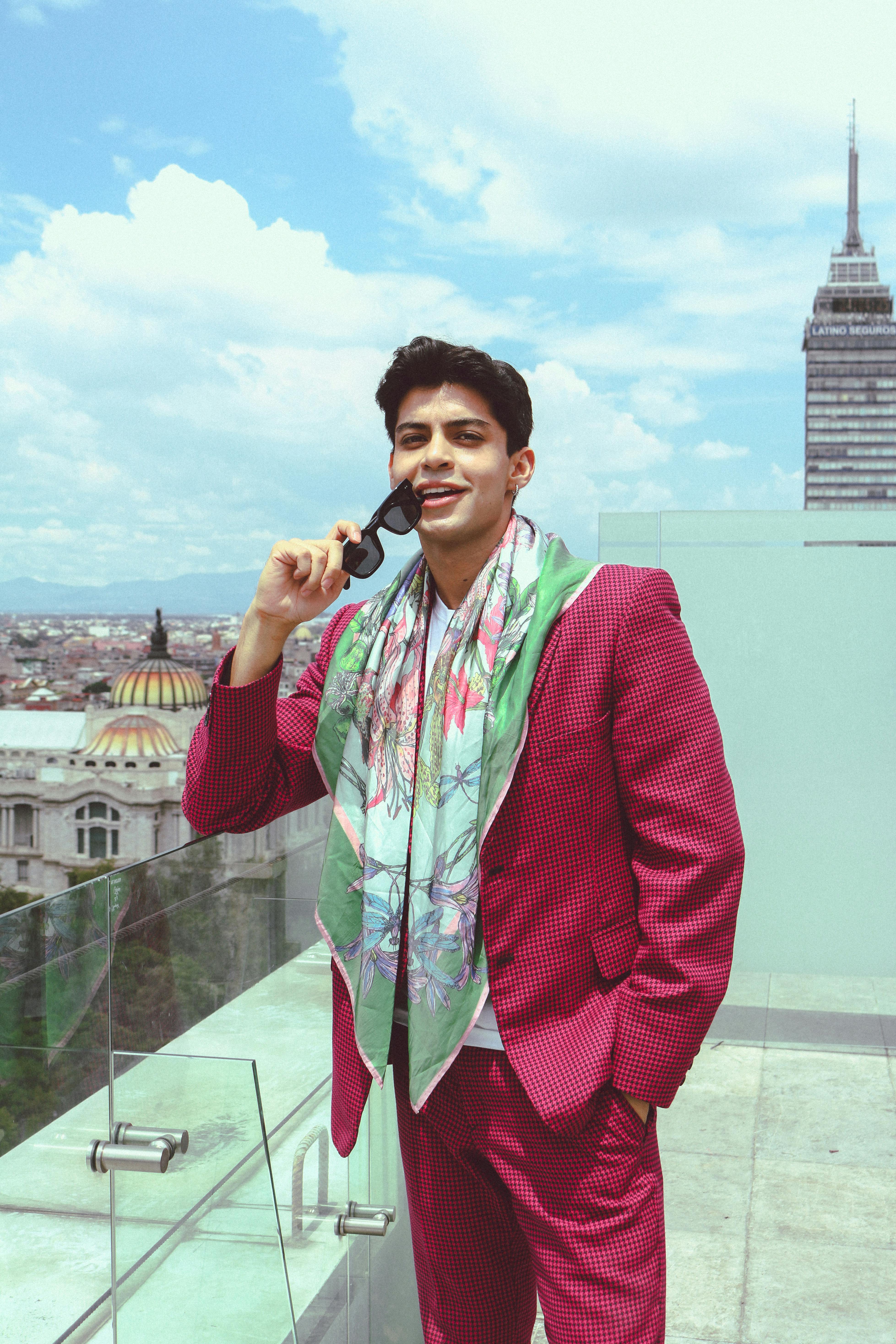 Modern man enjoying a bright rooftop day with a city skyline backdrop, exuding confidence and style.