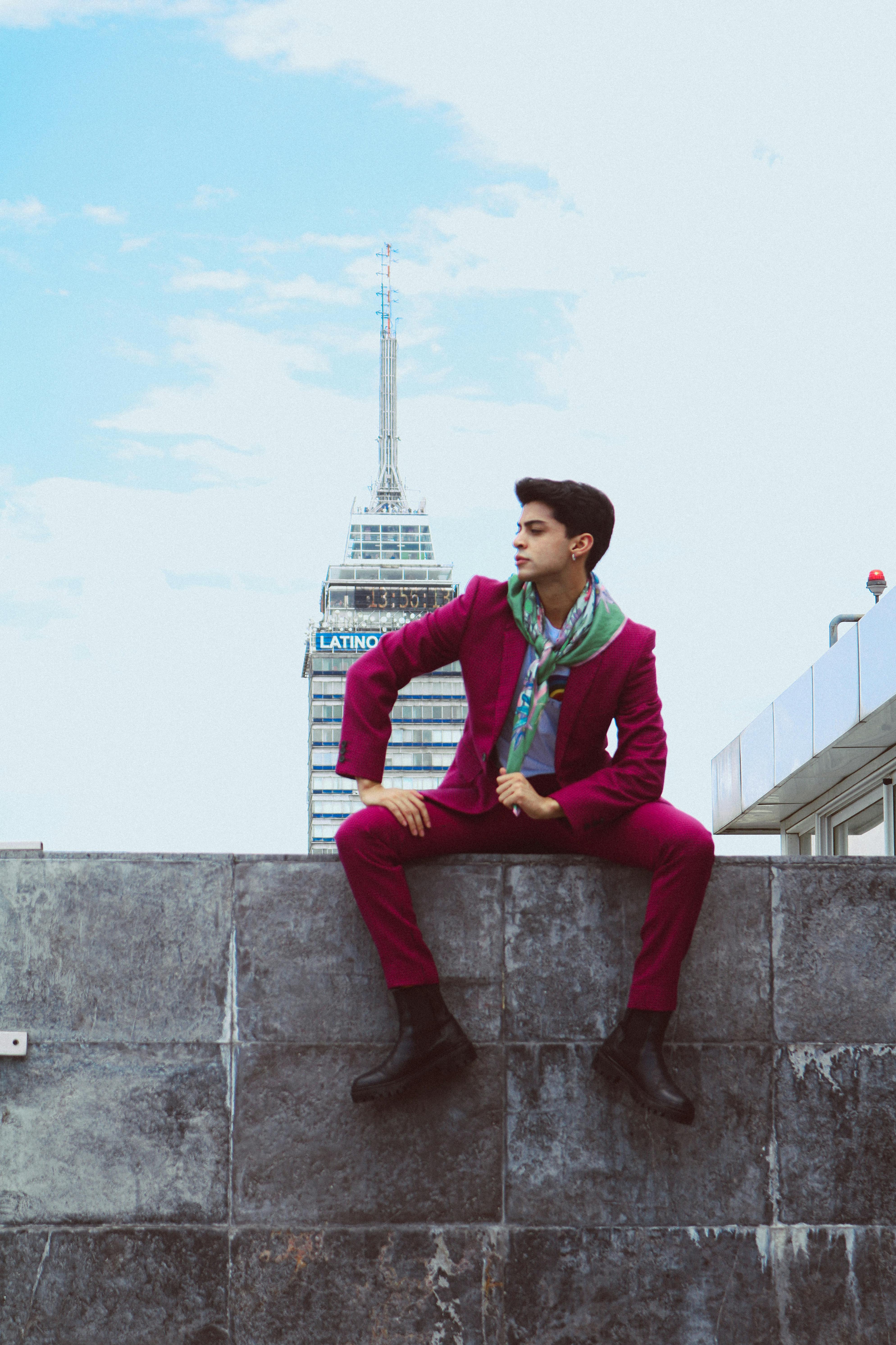 Young man in magenta suit posing with Torre Latinoamericana in the background.