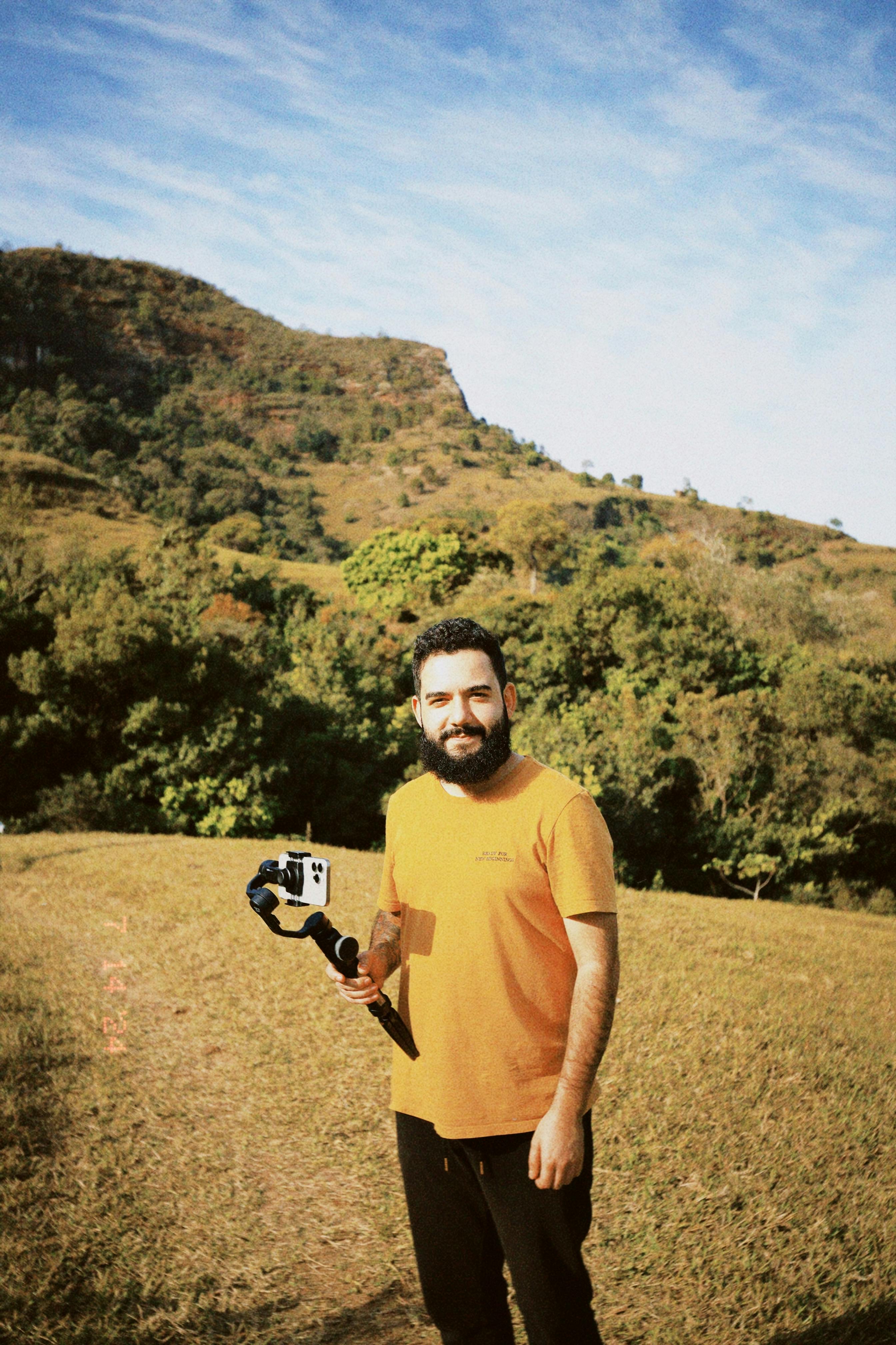 a man holding a camera in a field