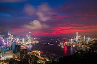 黄昏时分，从空中俯瞰香港，充满活力的天际线与港口构成一幅令人惊叹的画卷，发光的摩天大楼尽收眼底