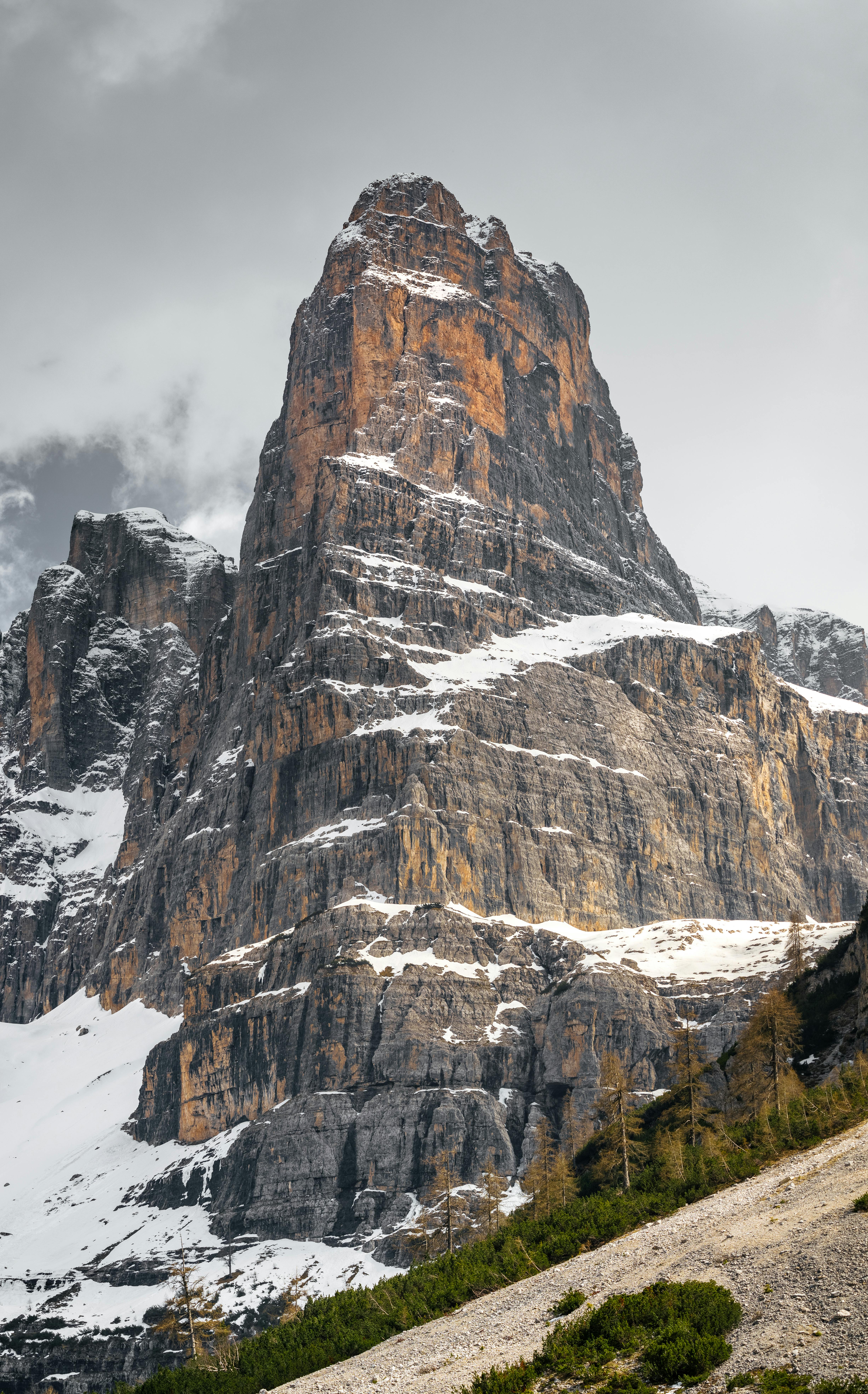 a mountain with snow on it and a cloudy sky