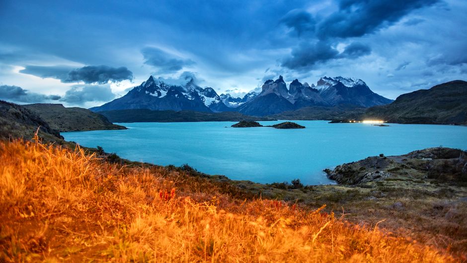 Dramatic twilight landscape of Torres del Paine with vibrant lake and mountains.