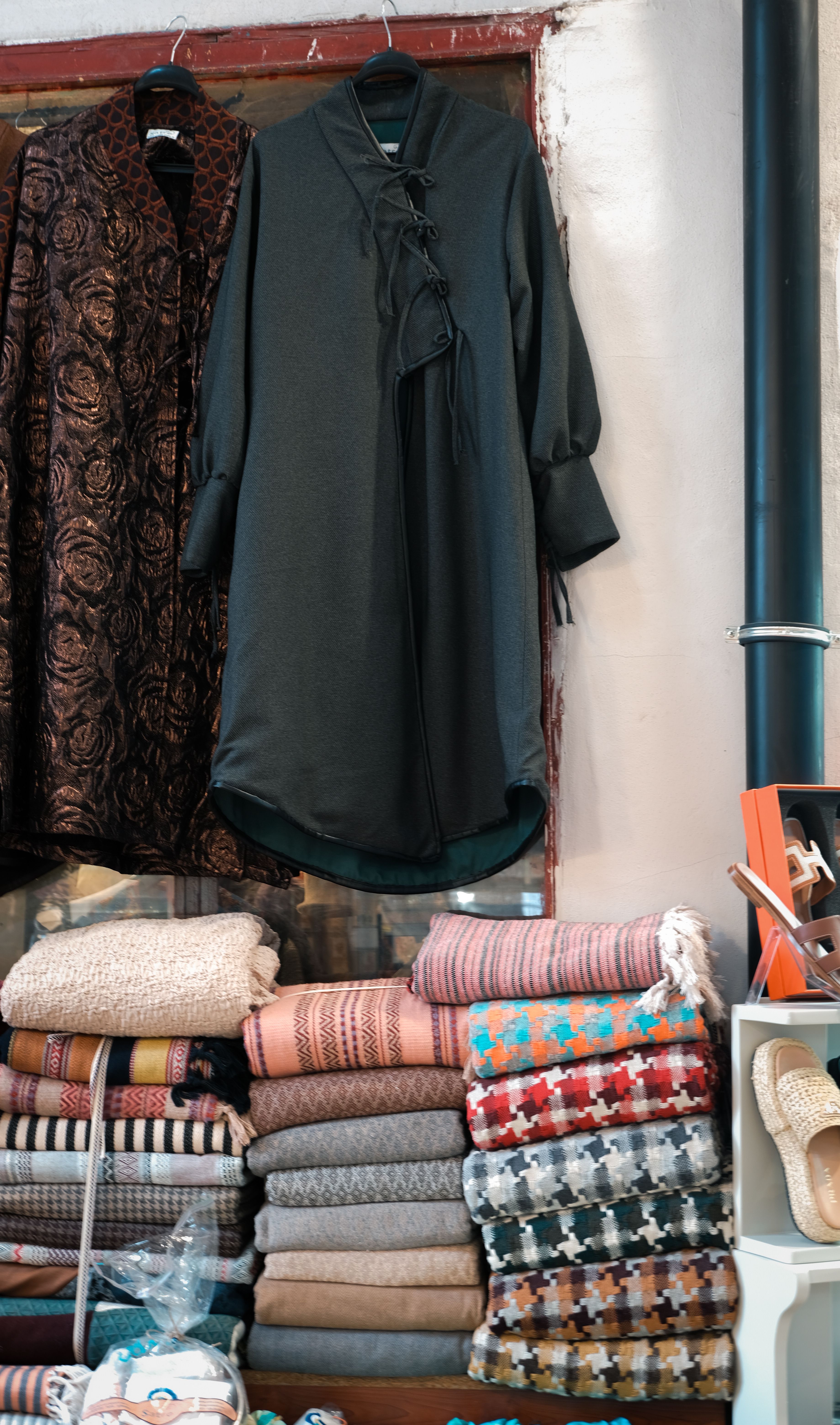 Stylish boutique interior showcasing elegant dresses and colorful folded scarves.