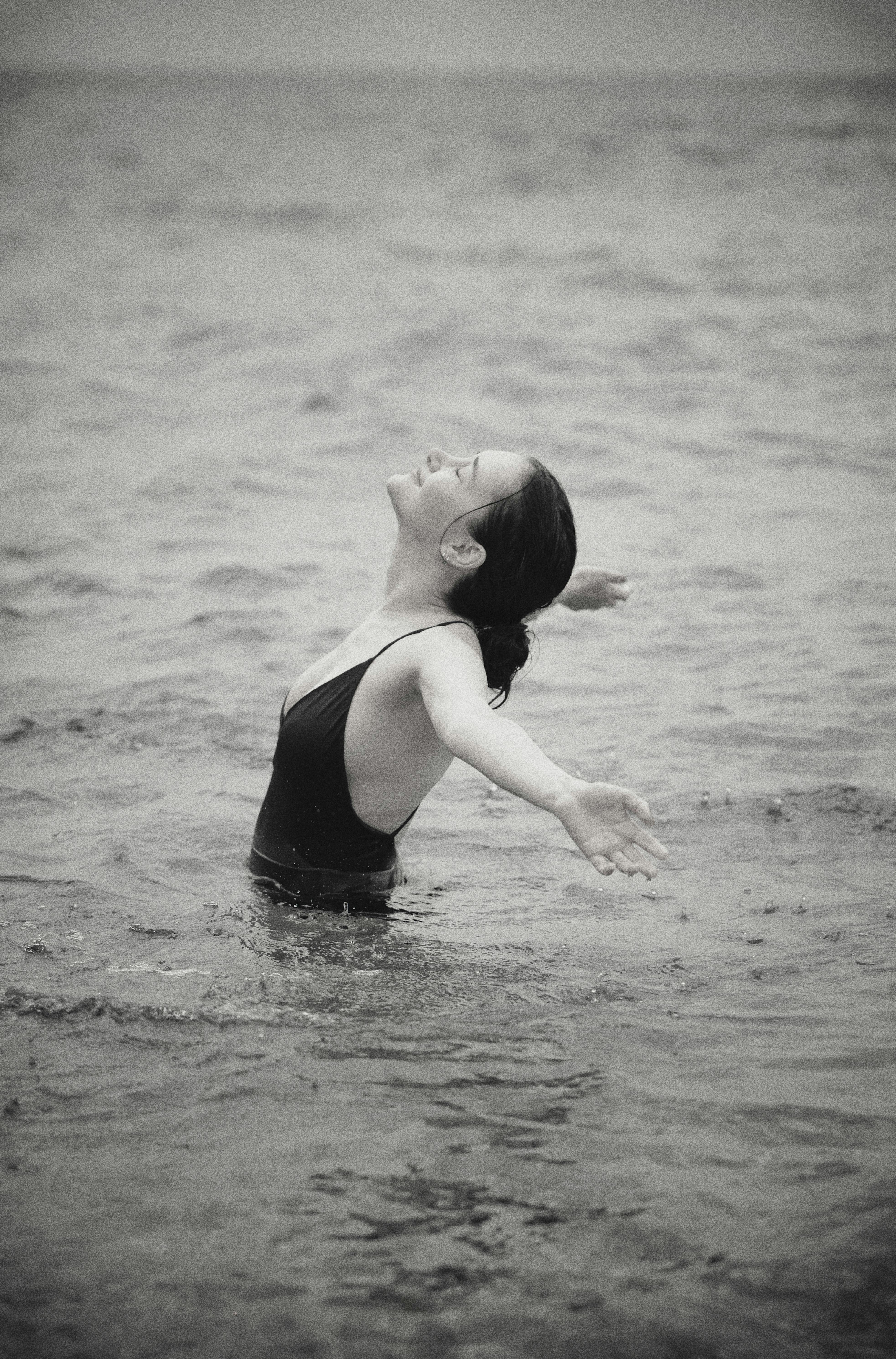 a woman in a black swimsuit is in the water