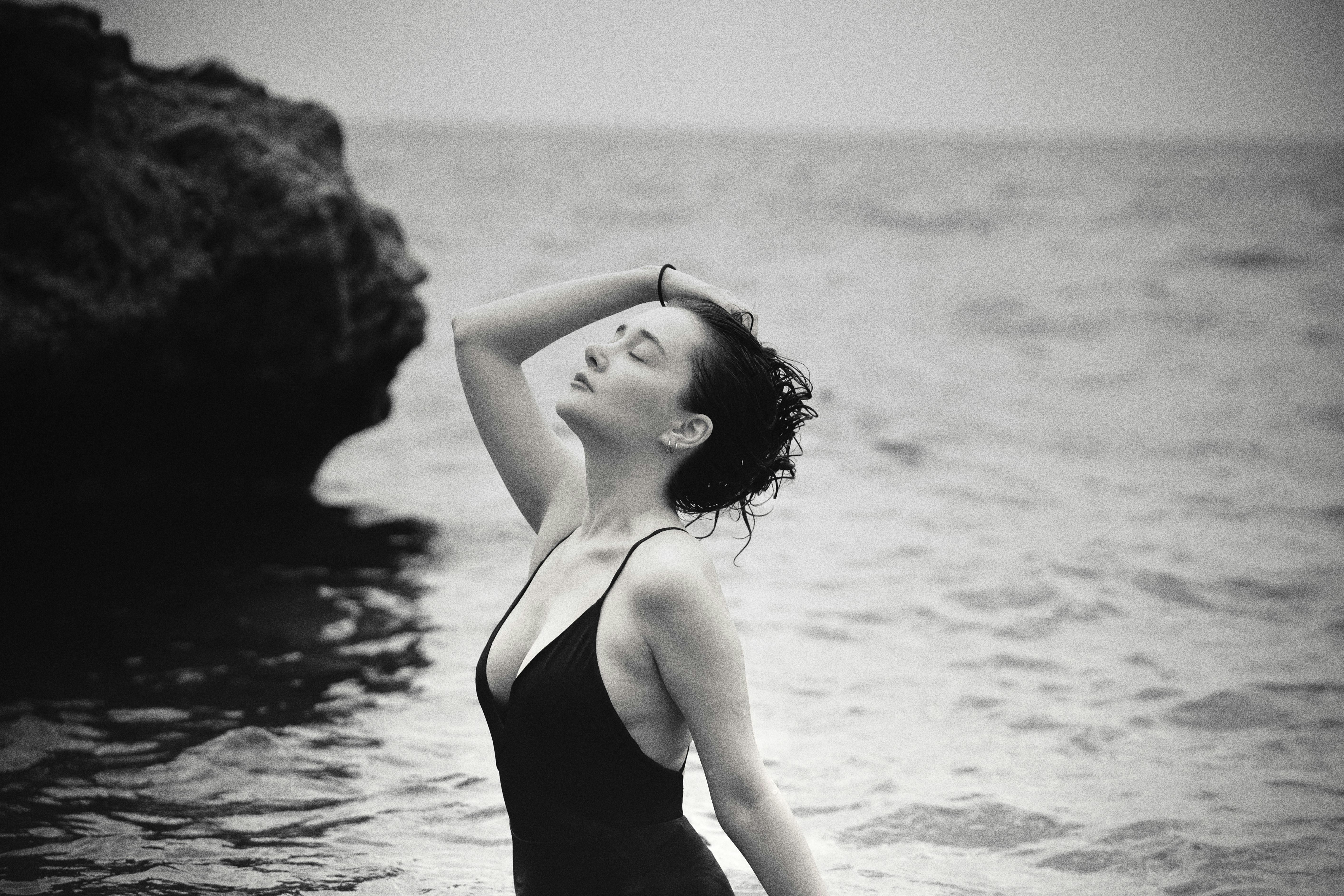 Black and white portrait of a woman enjoying the serene seaside in Antalya.
