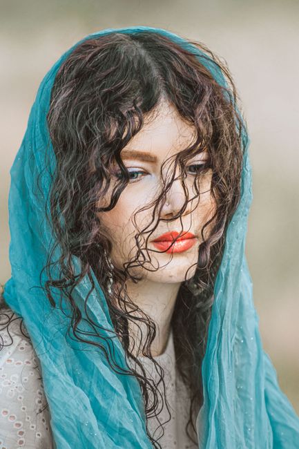 Portrait of a woman in Hamedan, Iran with a vibrant blue scarf and red lips.
