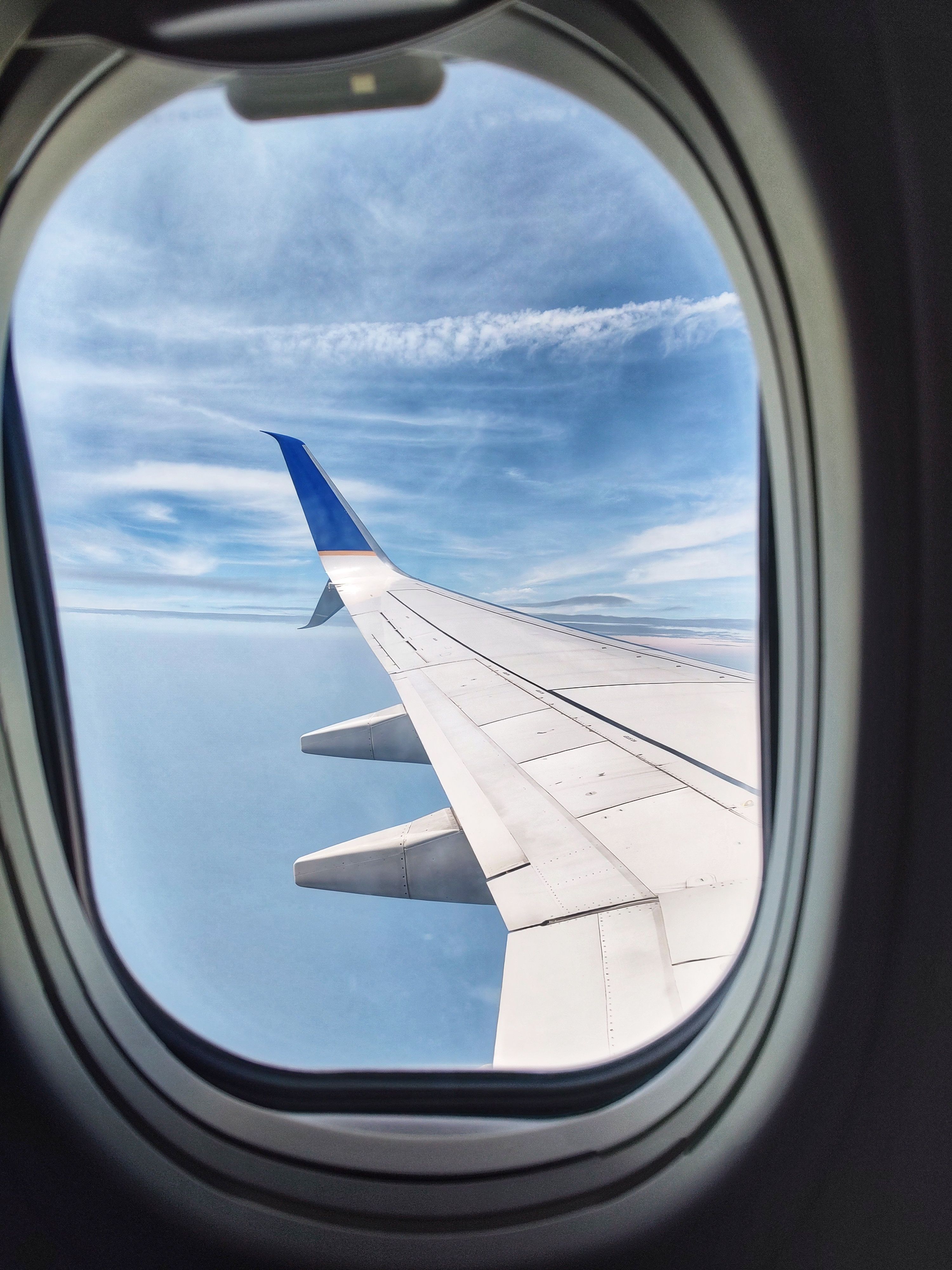 Wing of Flying Airplane behind Window · Free Stock Photo