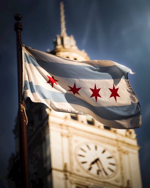 Shallow Focus Photography of Flag of Chicago Near Clock Tower