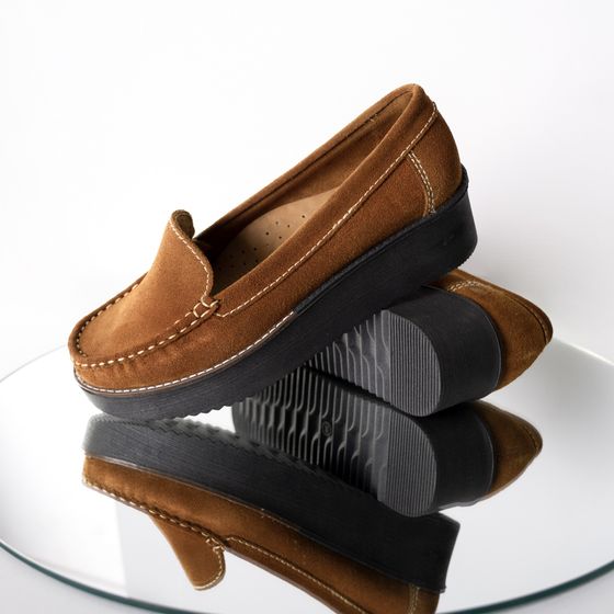 Tan suede loafers stacked on a glass surface, photo by Jose Martin Segura Benites on Pexels